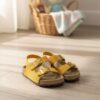 Yellow two strap baby sandals with adjustable buckles and soft cushioned sole for comfortable everyday wear